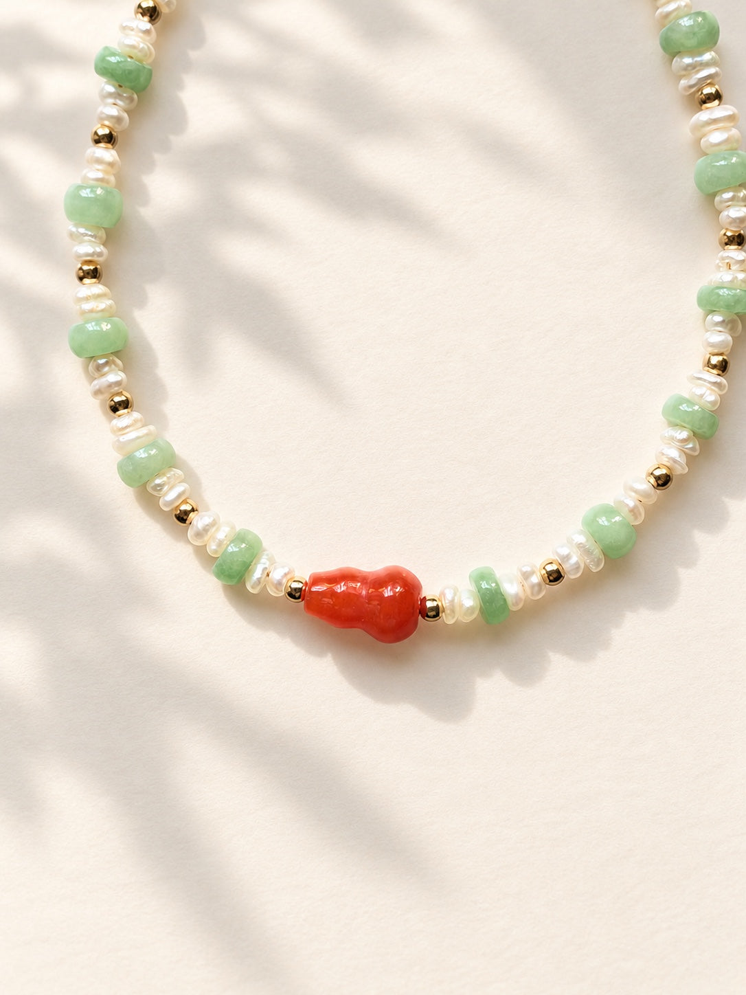 Close-up of gourd centerpiece, jadeite beads and freshwater pearls