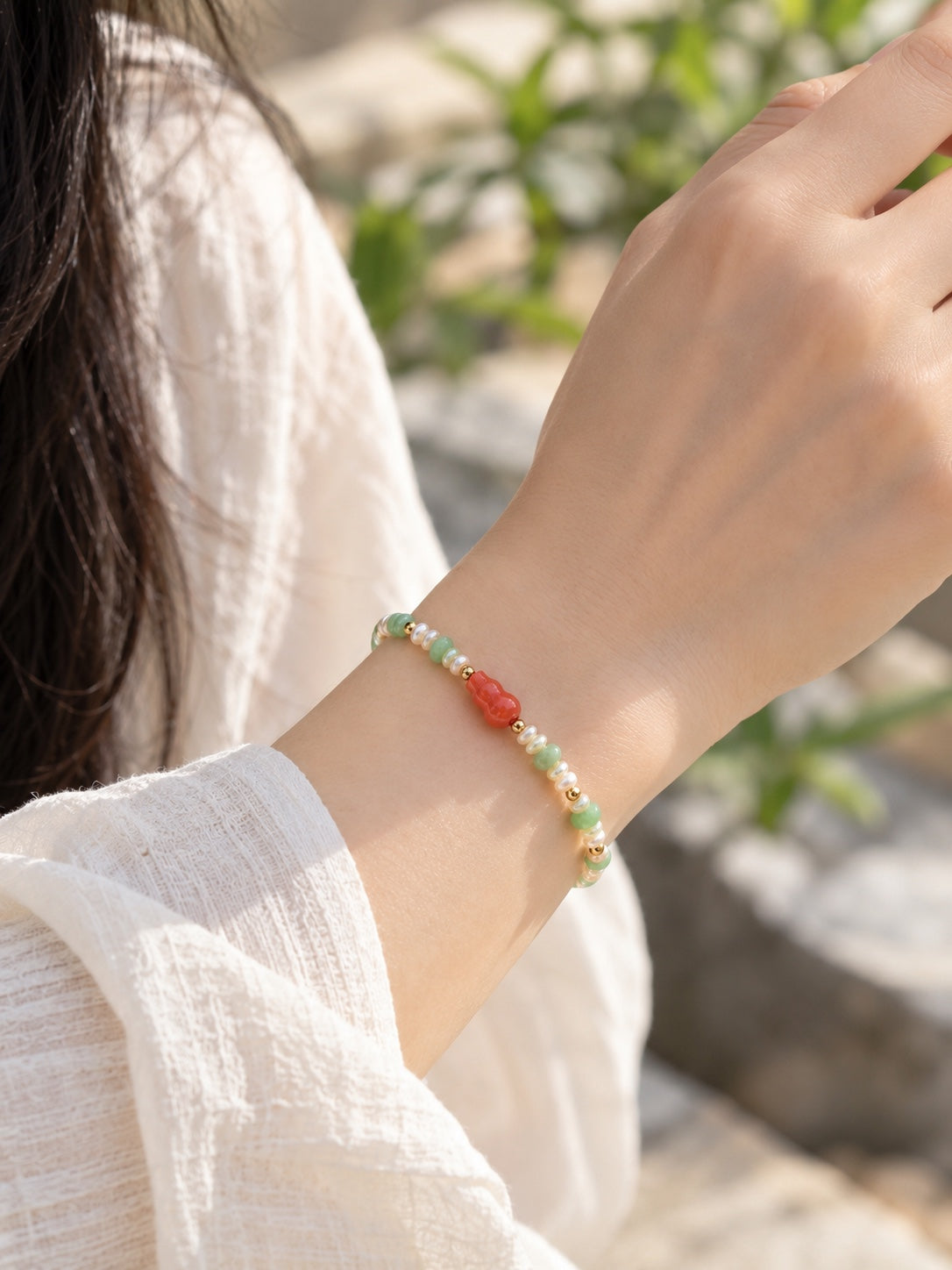 Jadeite and freshwater pearl gourd bracelet worn on wrist