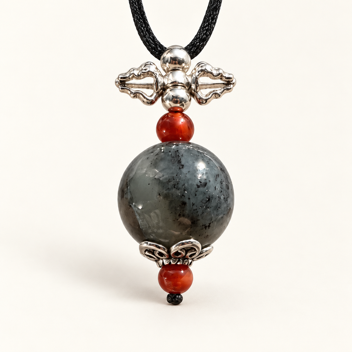 Black and gray nephrite vajra pendant with Nanhong agate and sterling silver, angle view