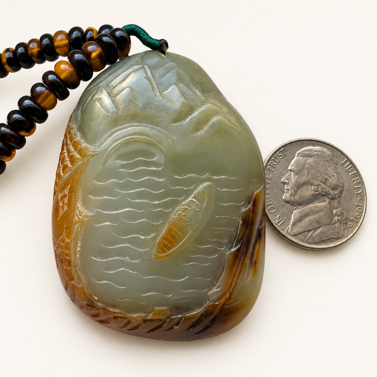 Nephrite landscape carving beside a US nickel for approximate scale; coin not included.