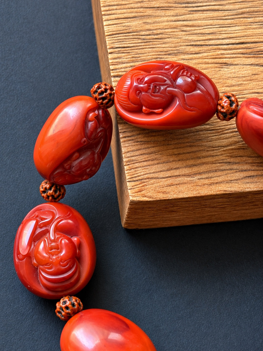 Close-up of Eight Immortals carvings in red Nanhong agate with bodhi seed spacers