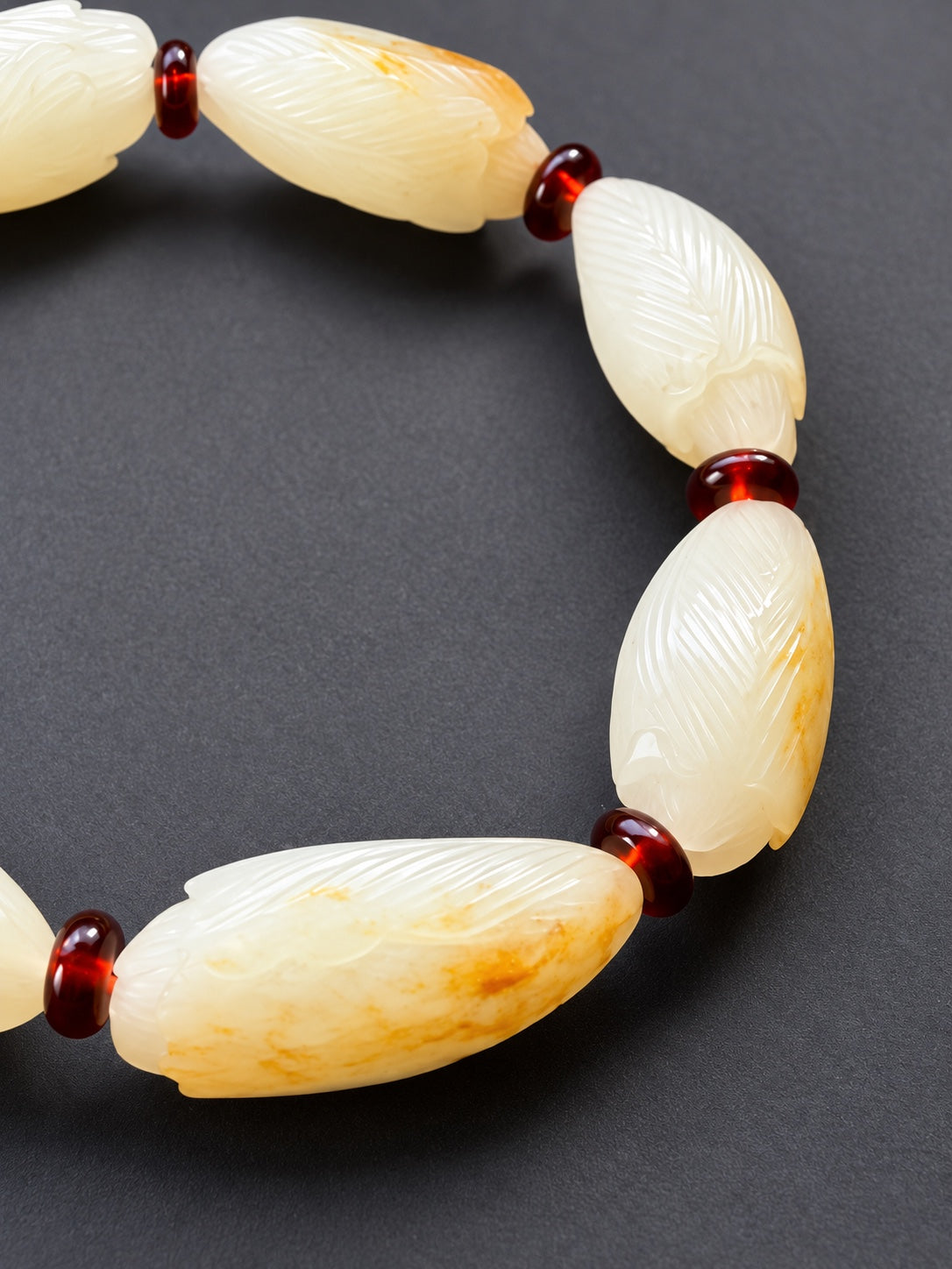 Close-up of magnolia carvings and natural skin coloration on nephrite jade beads