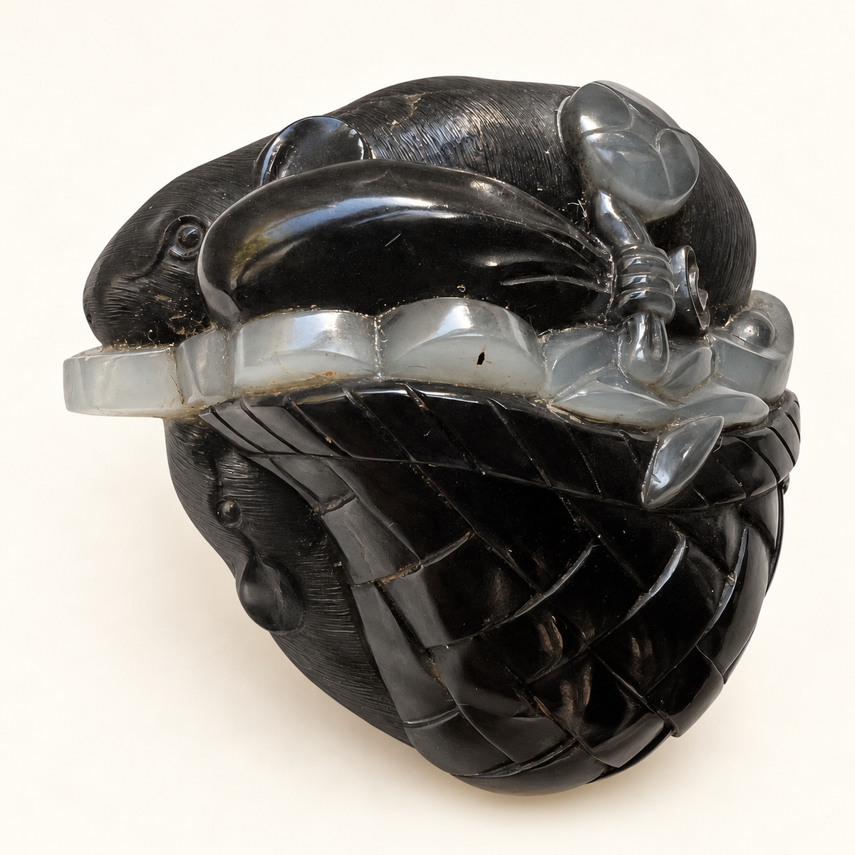 Retouched detail view of the black and white nephrite mice and coin pouch carving on a warm ivory background
