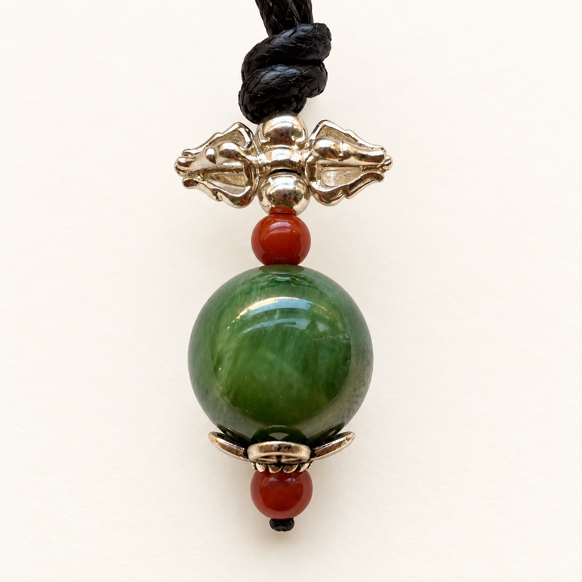 Detail of green nephrite jade, Nanhong agate and 925 sterling silver vajra pendant.