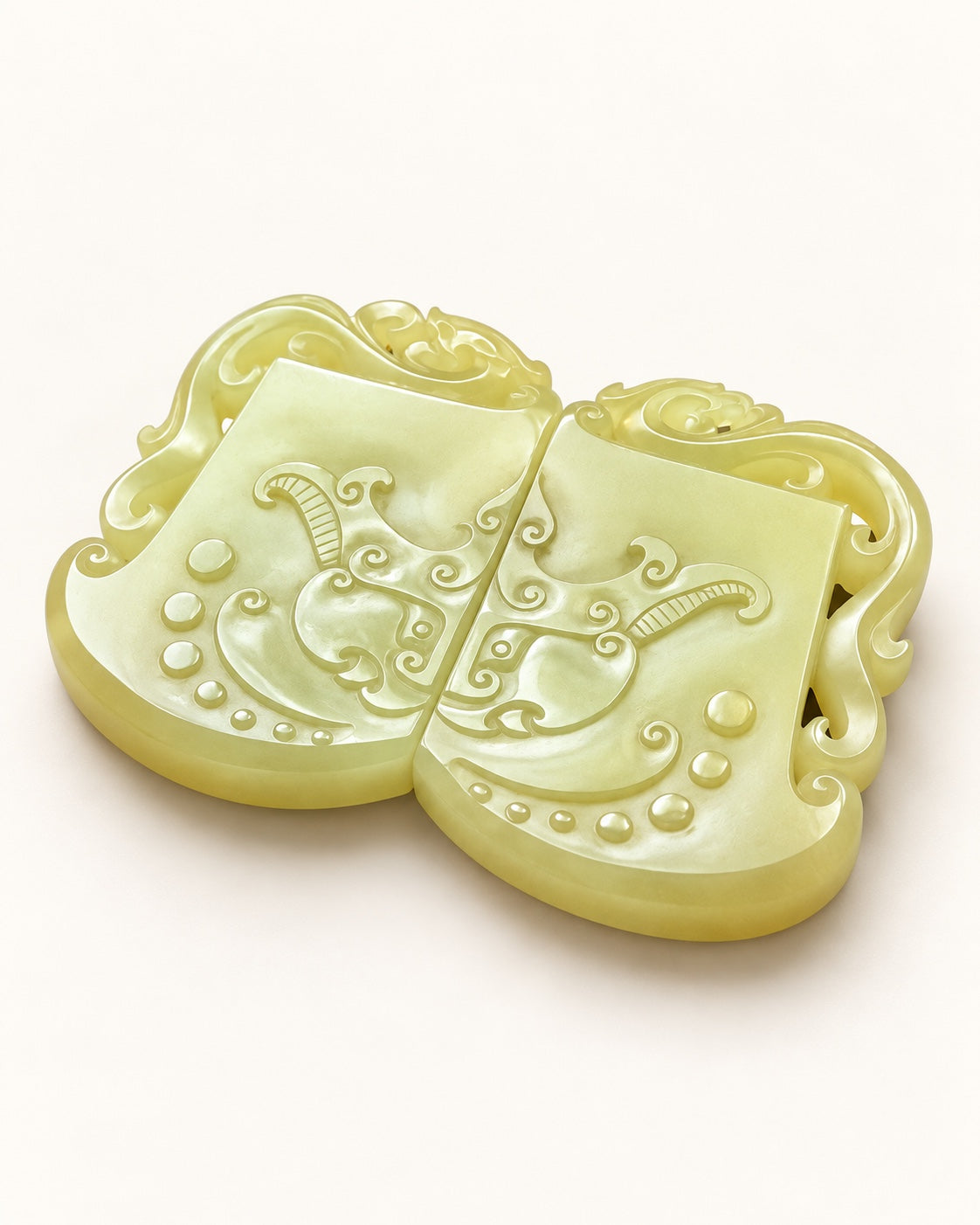 Angled view of a pair of yellow nephrite jade plaques with pierced scroll borders