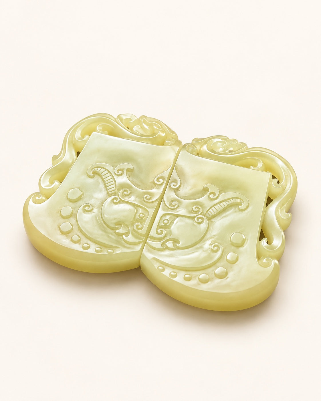 Yellow nephrite jade plaque pair showing carved scrolls and raised circular details