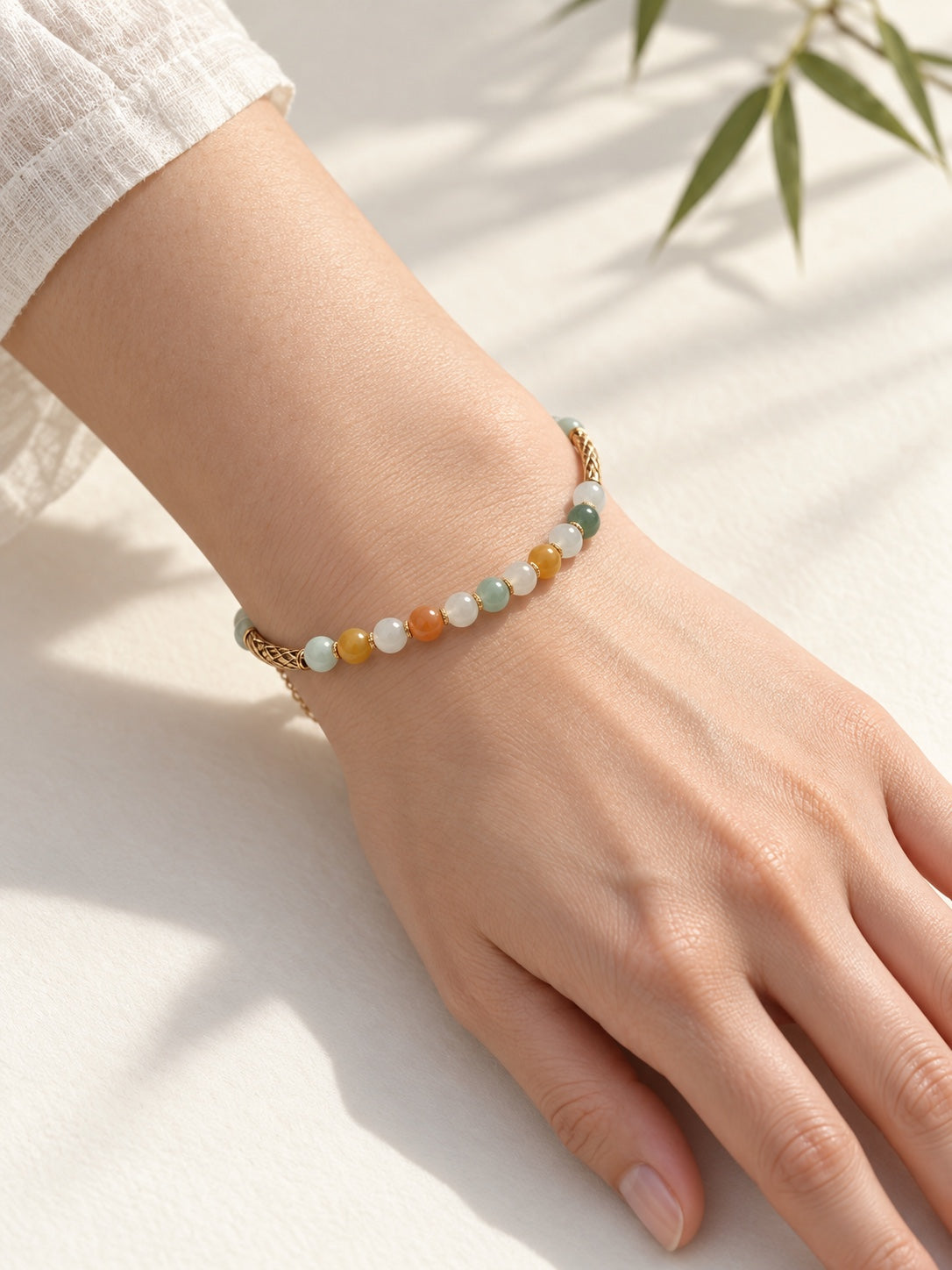 Multicolor 6 mm jadeite bracelet with 14K gold-filled curved tubes worn on wrist