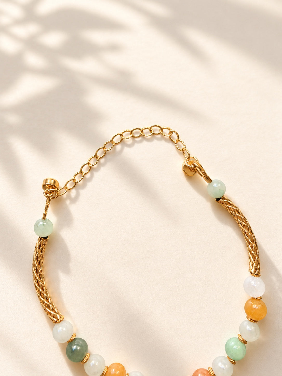 Close-up of gold-filled clasp and chain on multicolor jadeite bracelet