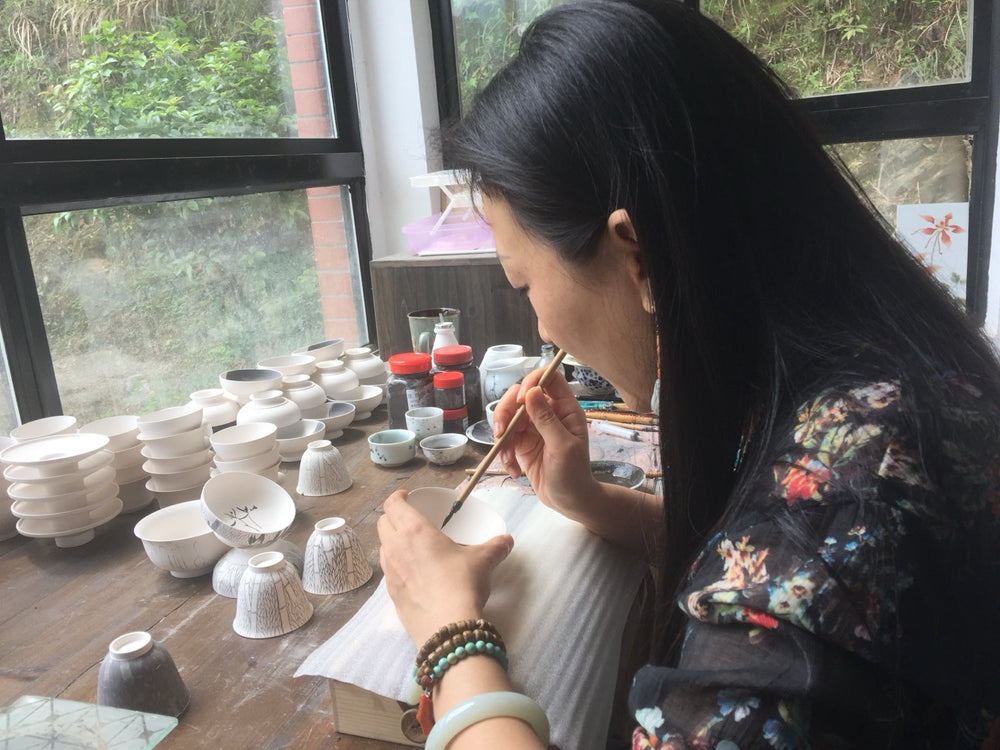 Lan painting a ceramic bowl during her 2016 study trip to Jingdezhen