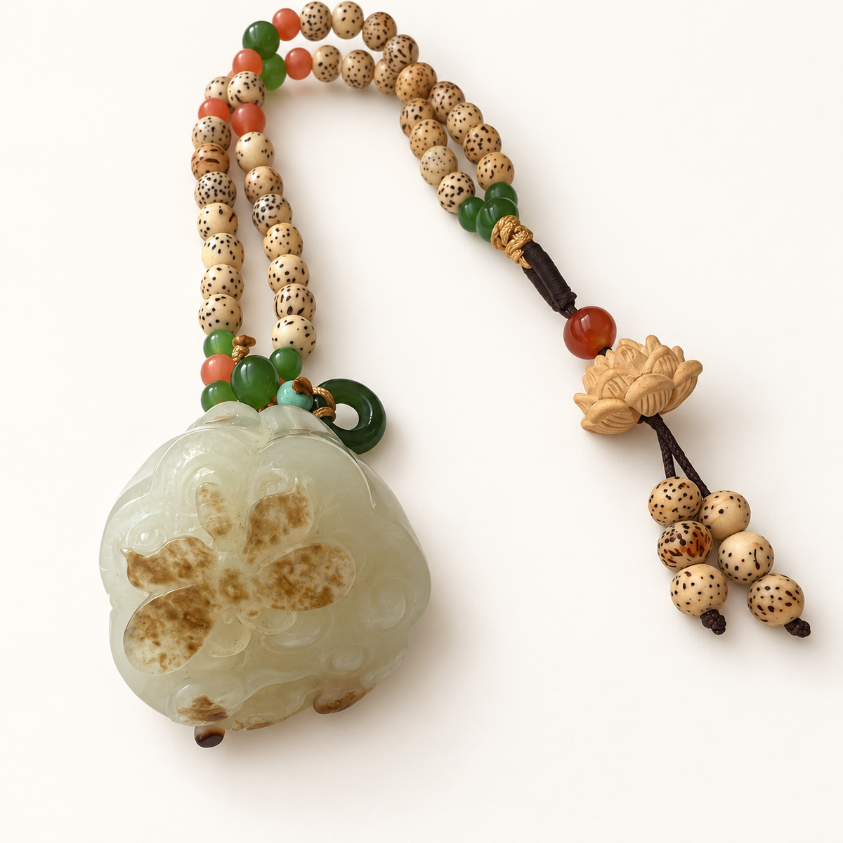 Lotus and butterfly nephrite pendant with its beaded cord and lotus charm.