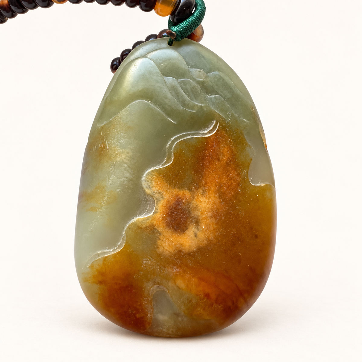 Reverse of the nephrite jade carving, showing its natural honey-brown skin and gray-green jade.