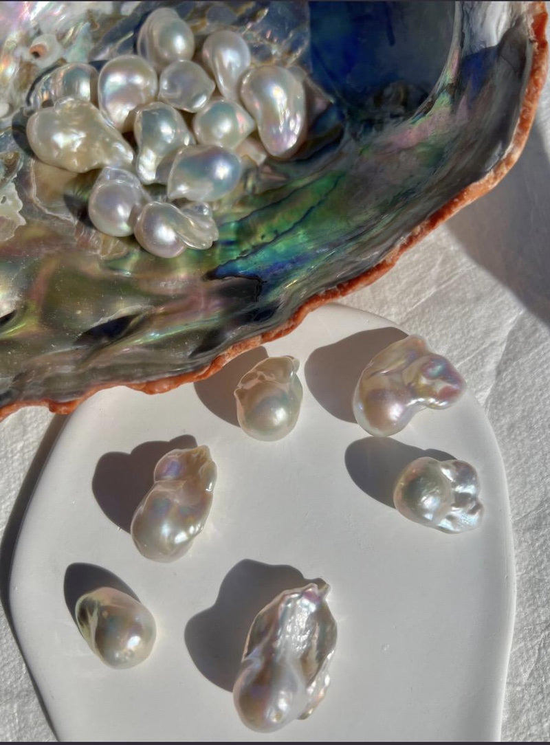 Loose Baroque pearls resting in a shell.