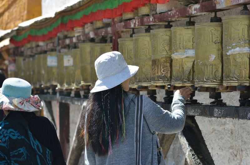A traveler turning prayer wheels, from the founder’s travel archive.